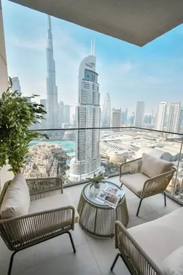 a balcony with chairs and tables and a view of a city at Burj Roayle-Magical Burj & Fountain Sky Views 3+1 BR APT in Dubai