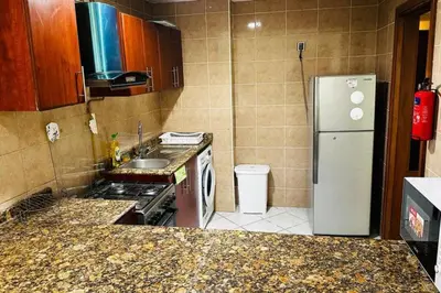 a small kitchen with a refrigerator and a sink at The Sand Castle- Pinnacle tower, Dubai Marina, Near metro in Dubai