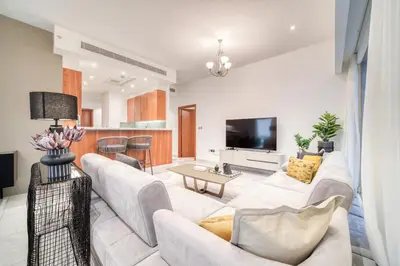 a living room with a white couch and a tv at Central Park Towers, City View - DIFC - Mint Stay in Dubai