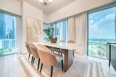 a dining room with a table and chairs and large windows at Central Park Towers, City View - DIFC - Mint Stay in Dubai