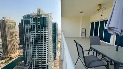 a balcony with a table and chairs and a view of a city at Jumeriah Lake Tower (JLT)-(LAKE VIEW) in Dubai