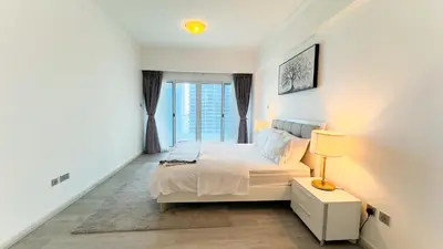 a white bedroom with a bed and a window at Jumeriah Lake Tower (JLT)-(LAKE VIEW) in Dubai