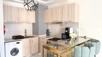 a kitchen with wooden cabinets and a glass counter top at Ahlan HH - Charming Studio at AG Tower in Dubai