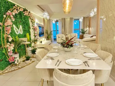 a dining room with a table and a green wall at Life Above Clouds in Dubai