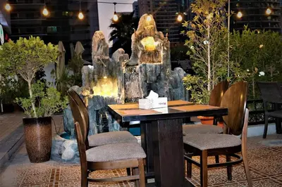 a table and chairs in front of a fountain at Life Above Clouds in Dubai