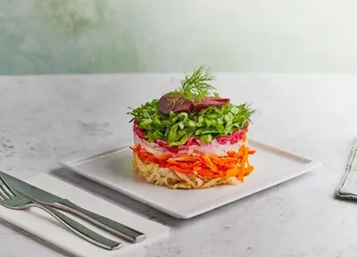 a sandwich on a plate on a table with a fork at Life Above Clouds in Dubai