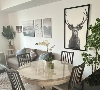 a living room with a table with a deer on the wall at Marina view with Pool, Gym, Tennis Court, 5 mins to Beach in Dubai