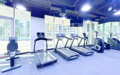 a gym with several treadmills and elliptical machines at Marina view with Pool, Gym, Tennis Court, 5 mins to Beach in Dubai