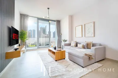 a living room with a white couch and a large window at LUX LIV Contemporary Full Marina View Suite in Dubai