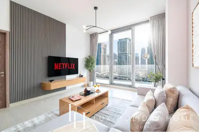 a living room with a couch and a tv at LUX LIV Contemporary Full Marina View Suite in Dubai