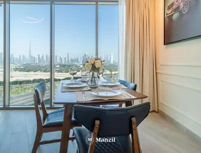 a dining room with a table and a large window at Azizi Farhad in Dubai