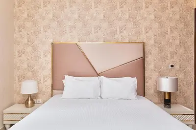 a bed with white pillows and two lamps at BellaVista - Graceful - 1 BR - 29 Boulevard - with Burj Khalifa View in Dubai