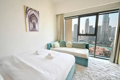 a hotel room with two beds and a window at Burj Royale-Enchanting Burj&Fountain full view Sky APT 3+1BR in Dubai