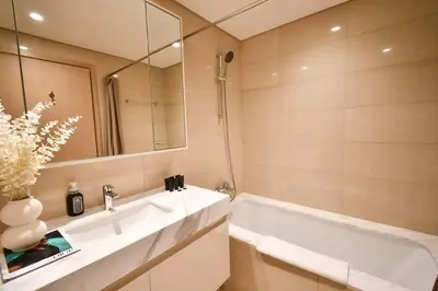 a bathroom with a sink and a tub and a mirror at Burj Royale-Enchanting Burj&Fountain full view Sky APT 3+1BR in Dubai
