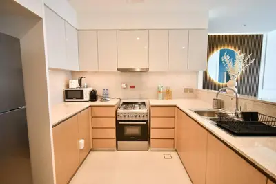 a kitchen with white cabinets and a stove top oven at Burj Royale-Enchanting Burj&Fountain full view Sky APT 3+1BR in Dubai