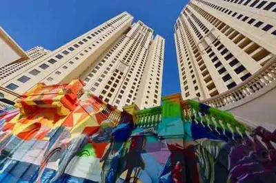 two tall buildings with a colorful display in between them at Your Cosy Dubai Marina Home in Dubai