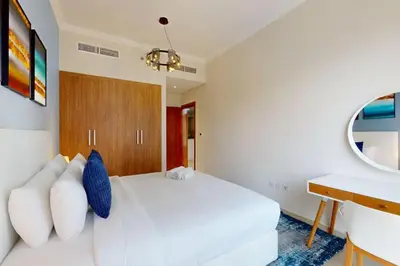 a bedroom with a white bed and a desk at Vacationer l Premium One Bed I Walk to Dubai Mall, Burj Khalifa I Dunya Tower Downtown in Dubai