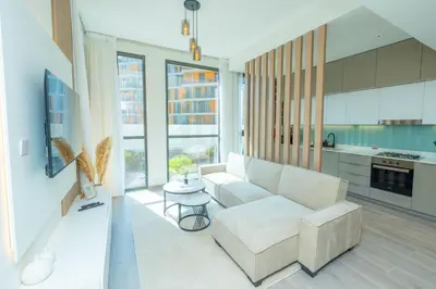 a living room with a couch and a table at Midtown Haven Cozy One Bed in Dubai in Dubai