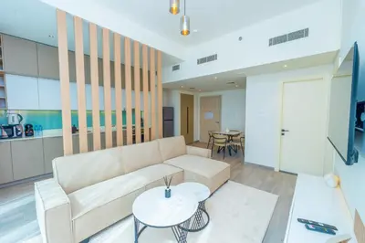 a living room with a couch and a table at Midtown Haven Cozy One Bed in Dubai in Dubai