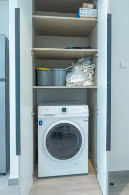 a laundry room with a washing machine in a closet at Midtown Haven Cozy One Bed in Dubai in Dubai