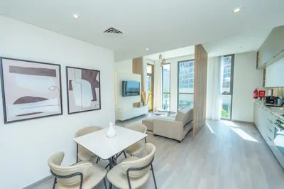 a living room with a table and chairs at Midtown Haven Cozy One Bed in Dubai in Dubai