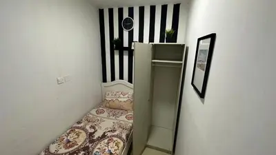 a small room with a bed and a shelf at Solo Partition Room in Al Barsha 1 Near Mashreq Metro in Dubai