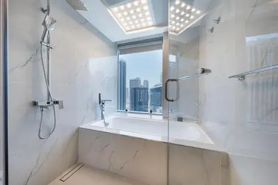 a bathroom with a shower and a sink and a window at Luxury Address Res Dubai Marina Studio in Dubai