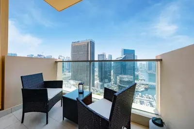 a balcony with a table and chairs and a view of the city at Luxury Address Res Dubai Marina Studio in Dubai