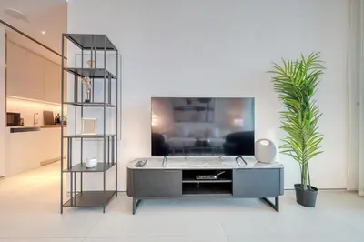 a living room with a table in front of a tv at Address JBR with Sea View & Maid Room - Mint Stay in Dubai
