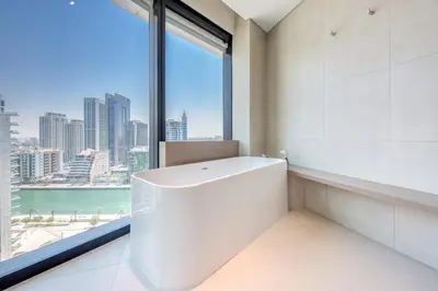 a bathroom with a bath tub and a large window at Address JBR with Sea View & Maid Room - Mint Stay in Dubai