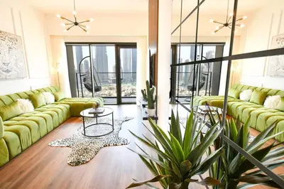 a living room with green couches and a table at cinematic&Chic Burj Khalifa &Fountain View 2BR APT in Dubai