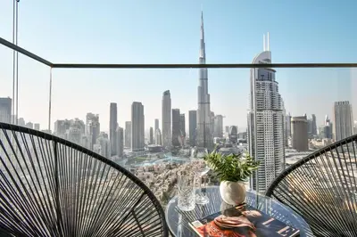 a glass table with chairs and a view of a city at cinematic&Chic Burj Khalifa &Fountain View 2BR APT in Dubai