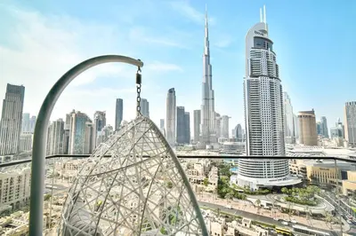 a ferris wheel in a city with tall buildings at cinematic&Chic Burj Khalifa &Fountain View 2BR APT in Dubai