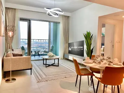 a living room with a table and a dining room at Luxurious 1-bedroom With Skyline View In Downtown Views Ii in Dubai
