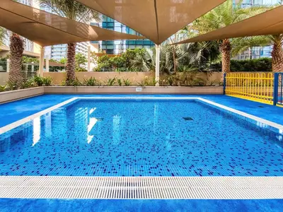 a swimming pool with blue water in a building at Amazing 1 BD in Marina Gate 2 Dubai Marina in Dubai