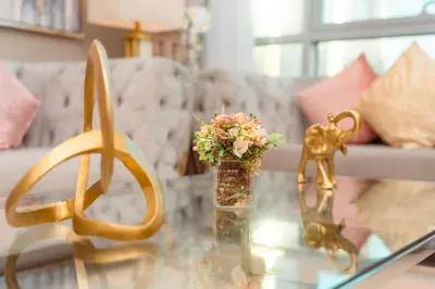a living room with a glass table with flowers and gold items at Elite Royal Apartment - Full Burj Khalifa & Fountain View - 2 Bedrooms + 1 Open Bedroom Without Partition - Magnate in Dubai
