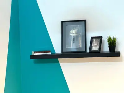 a shelf with two pictures and a picture of a hat at Cityview Partition Room with Balcony in Tecom in Dubai