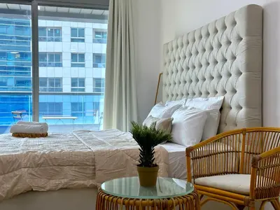 a bedroom with a large bed and a large window at Luxury Studio w/ BoHo Design and Balcony for 4 Pax in Dubai