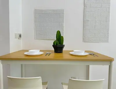 a table with two plates and a plant on it at Luxury Studio w/ BoHo Design and Balcony for 4 Pax in Dubai