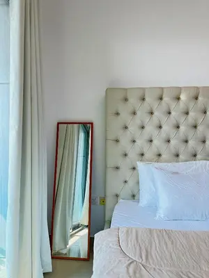 a bedroom with a mirror next to a bed at Luxury Studio w/ BoHo Design and Balcony for 4 Pax in Dubai