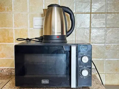 a coffee pot sitting on top of a microwave at Luxury Studio w/ BoHo Design and Balcony for 4 Pax in Dubai
