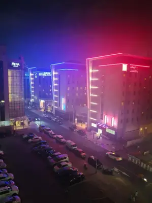 a city at night with cars parked in a parking lot at Partition Room 3 Mins to Mashreq Metro in Dubai