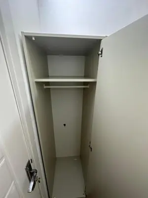 a small closet with white shelves and a door at Beautiful Partition Strip Room in Barsha Heights in Dubai