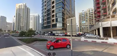 a red car parked in a parking lot in a city at Bachelor Partition Room in Tecom Near Internet City Metro in Dubai