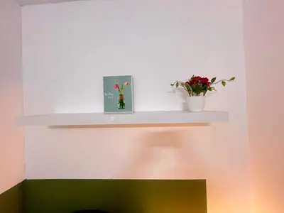 a shelf with flowers and a picture on it at Bachelor Partition Room in Tecom Near Internet City Metro in Dubai