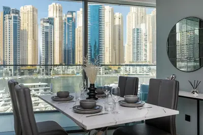 a dining room table with a view of a city at Luxurious 2BR apt with panoramic Marina view in Dubai