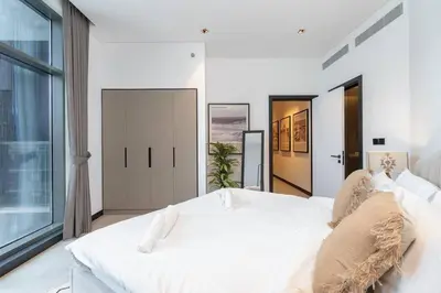 a bedroom with a large white bed and a window at Ranch Living 1 bedroom apartment in Business Bay by Suiteable in Dubai
