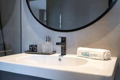 a bathroom sink with a mirror and a towel at Ranch Living 1 bedroom apartment in Business Bay by Suiteable in Dubai