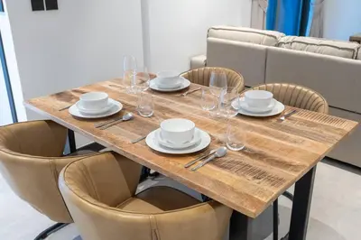 a wooden table with plates and wine glasses on it at Ranch Living 1 bedroom apartment in Business Bay by Suiteable in Dubai