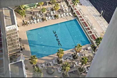 an overhead view of a pool with chairs and palm trees at Phineek Elegant Studio Canal View Maison Prive Business Bay in Dubai